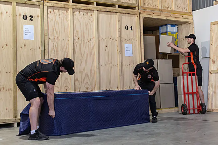 Wooden crate being loaded into a storage unit at a warehouse